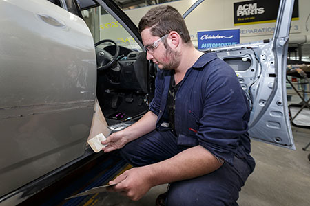 student working on a car with ACM Parts